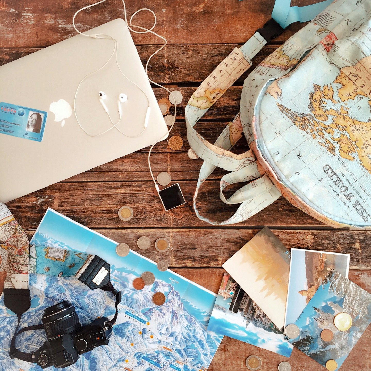Travel essentials laid out on a wooden table for a trip.